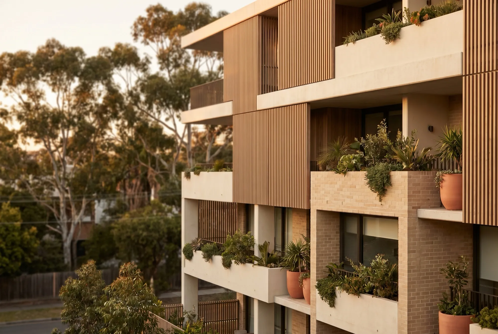 A modern Australian apartment building with balconies in golden light